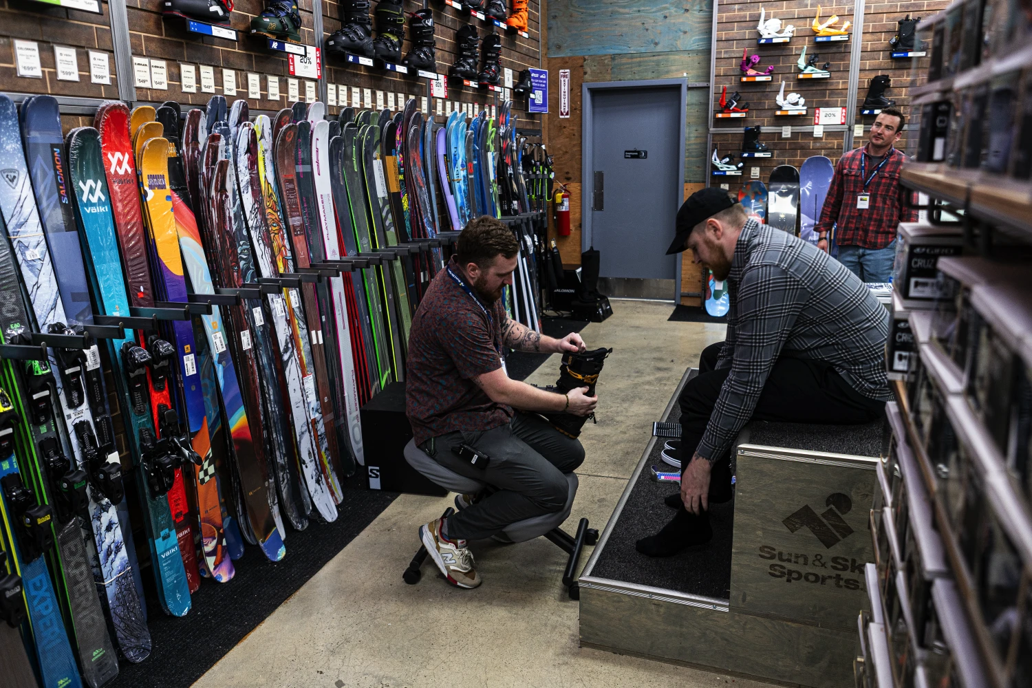 Customer being fitted for boots at a Sun & Ski Sports location.
